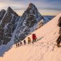 Mountaineers ascending a snow-covered peak in California's Sierra Nevada mountain range with climbing gear
