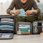 Traveler packing organized duffel bag with clothes and essentials for weekend trip