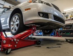 Hydraulic floor jack lifting a car in a garage