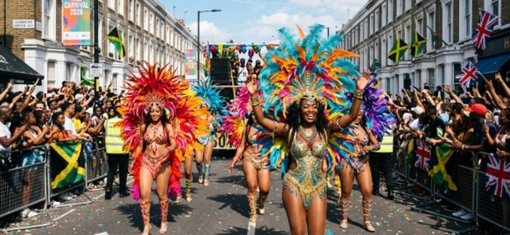 Colourfully costumed masqueraders parading down Ladbroke Grove with feathered headdresses and sequined costumes at Notting Hill Carnival 2026 in West London