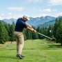 A gleaming set of custom golf irons displayed professionally on a pristine green turf.
