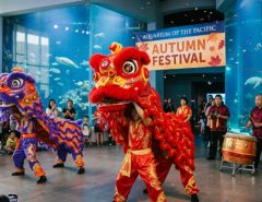 Performers in colorful traditional costumes during a lion dance at the Aquarium of the Pacific Autumn Festival
