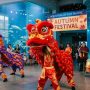 Performers in colorful traditional costumes during a lion dance at the Aquarium of the Pacific Autumn Festival