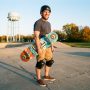 Beginner adult holding a skateboard at an Illinois skatepark